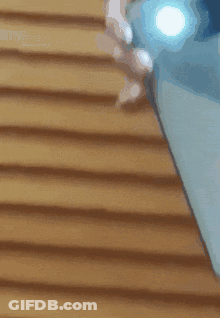 A Person Is Holding A Cell Phone With A Flashlight On It GIF