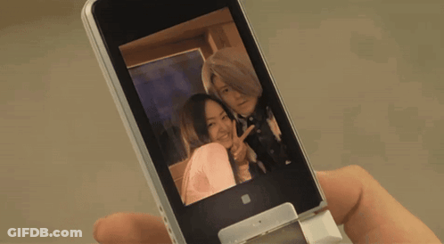 A Person Is Holding A Cell Phone With A Picture Of A Woman On It GIF