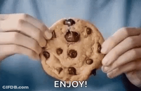 A Person Is Holding A Chocolate Chip Cookie In Their Hands And Says `` Enjoy '' . GIF