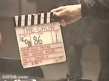 A Person Is Holding A Clapper Board That Says " The Crow " GIF