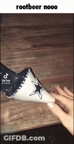 A Person Is Holding A Cone With A Cowboys Star On It . GIF