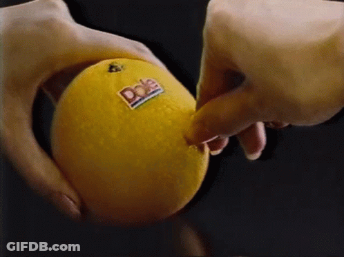 A Person Is Holding A Dole Orange In Their Hand GIF