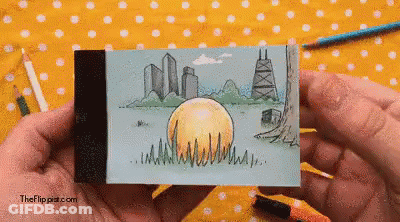 A Person Is Holding A Drawing Of A City Skyline With The Website Theflippat.com Visible In The Corner GIF