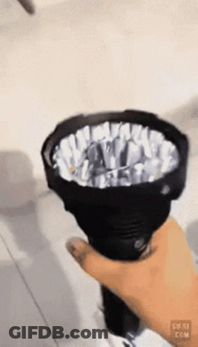 A Person Is Holding A Flashlight In Their Hand And The Flashlight Is Shining Brightly GIF
