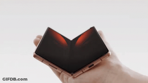 A Person Is Holding A Folded Phone In Their Right Hand GIF