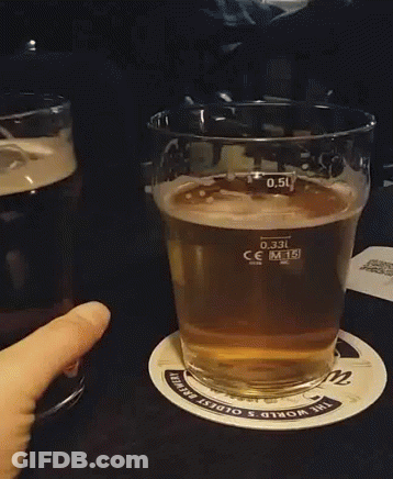 A Person Is Holding A Glass Of Beer On A Coaster That Says The World 'S Oldest Brewing GIF