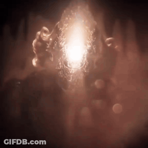 A Person Is Holding A Glowing Object In Their Hands In The Dark . GIF