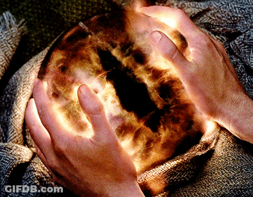 A Person Is Holding A Glowing Sphere In Their Hands GIF