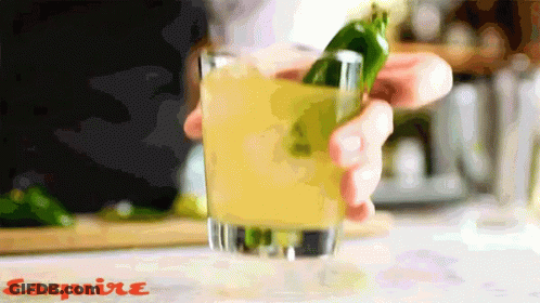 A Person Is Holding A Green Pepper In A Glass With Esquire Written On The Bottom Of The Image GIF