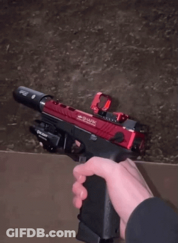 A Person Is Holding A Gun In A Warehouse GIF