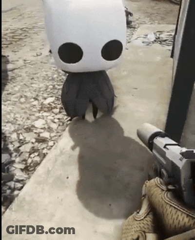 A Person Is Holding A Gun Next To A Stuffed Animal With Black Eyes GIF