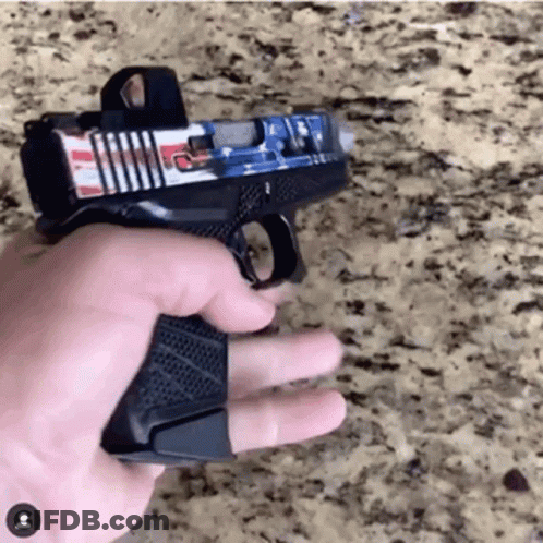 A Person Is Holding A Gun With An American Flag Sticker On It GIF