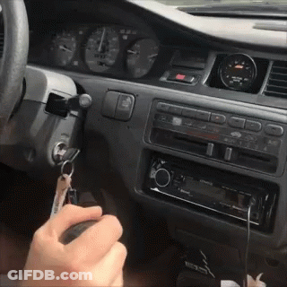 A Person Is Holding A Key In Their Hand In The Car GIF