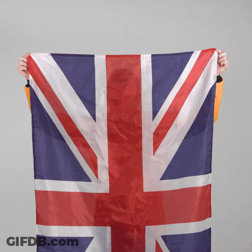 A Person Is Holding A Large British Flag In Their Hands GIF