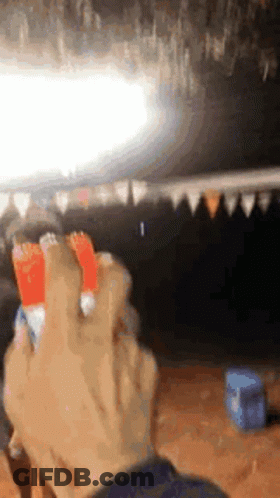 A Person Is Holding A Lighter In Their Hand In Front Of A Blurred Background . GIF
