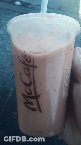 A Person Is Holding A Mcdonald 'S Cup With A Straw GIF