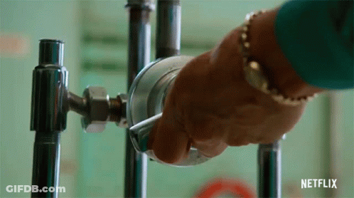 A Person Is Holding A Metal Object In Their Hand . GIF