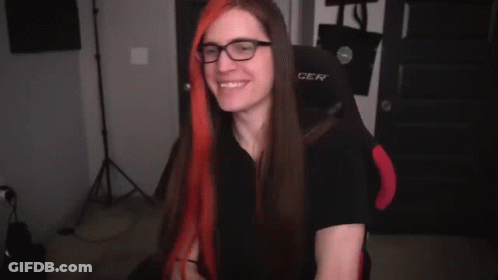 A Person Is Holding A Pair Of Scissors In Their Hands And Cutting A Piece Of Red Hair . GIF