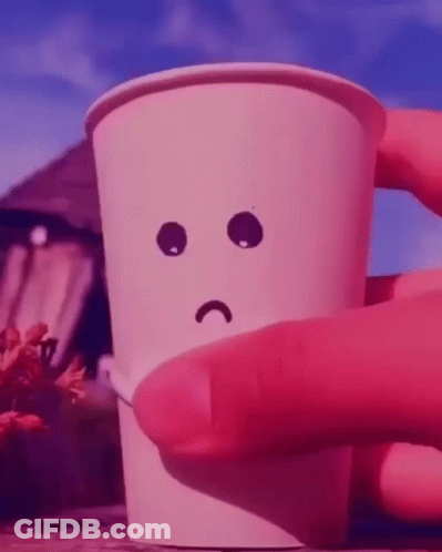 A Person Is Holding A Paper Cup With A Sad Face Drawn On It GIF