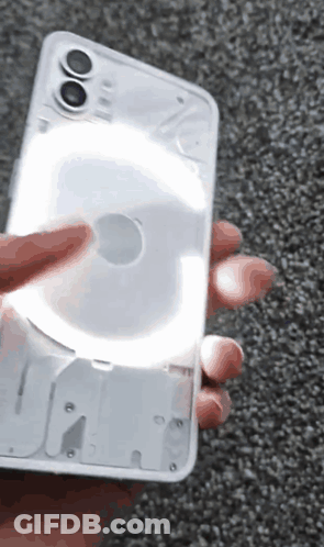 A Person Is Holding A Phone That Has A Light On It GIF