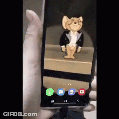A Person Is Holding A Phone With A Jerry Mouse On The Screen GIF