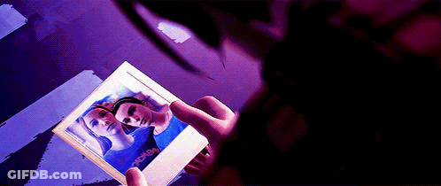 A Person Is Holding A Picture Of A Woman With The Word Women On It . GIF