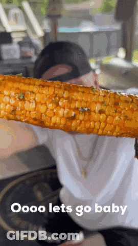 A Person Is Holding A Piece Of Corn On The Cob With The Words Oooo Lets Go Baby Below It GIF
