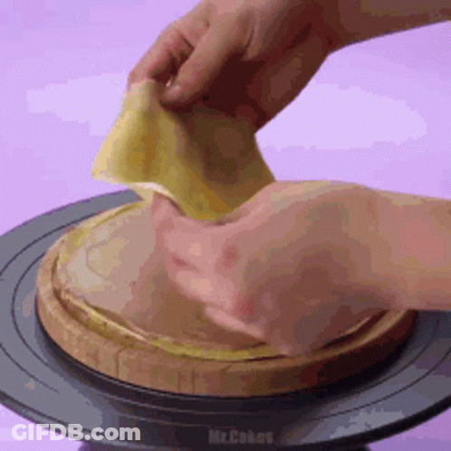 A Person Is Holding A Piece Of Food On Top Of A Wooden Board . GIF