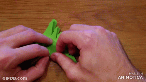 A Person Is Holding A Piece Of Green Paper That Says Made In Animotica On The Bottom GIF