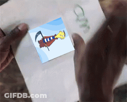 A Person Is Holding A Piece Of Paper That Has A Picture Of A Cartoon Character On It GIF