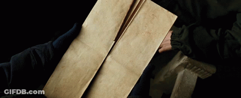 A Person Is Holding A Piece Of Paper That Is Very Old GIF