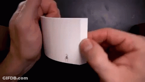 A Person Is Holding A Piece Of Paper With A Drawing On It . GIF