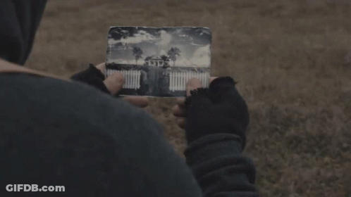 A Person Is Holding A Piece Of Paper With A Picture Of A House On It GIF