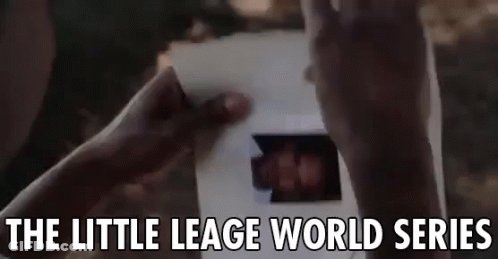 A Person Is Holding A Piece Of Paper With A Picture Of A Person On It . GIF