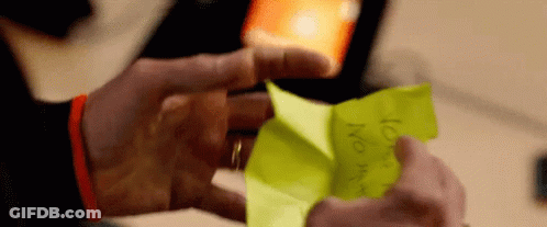 A Person Is Holding A Piece Of Yellow Paper That Says ' No ' On It GIF