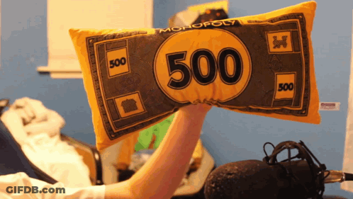A Person Is Holding A Pillow That Looks Like A Monopoly Money GIF
