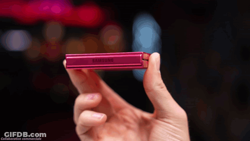 A Person Is Holding A Pink Samsung Device In Their Hand GIF