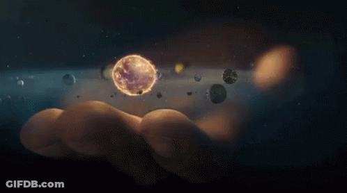 A Person Is Holding A Planet In Their Hand Surrounded By Planets GIF