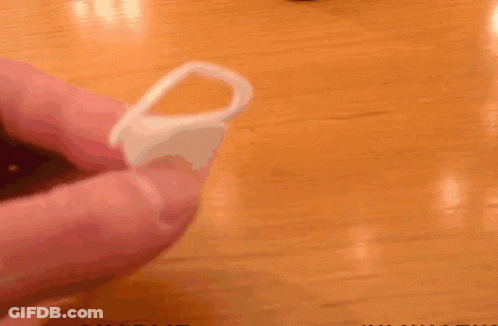 A Person Is Holding A Plastic Ring In Front Of A Pot With Charlie Written On It GIF