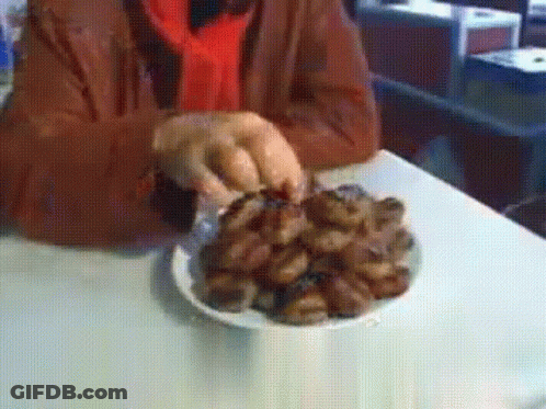 A Person Is Holding A Plate Of Food On A Table GIF