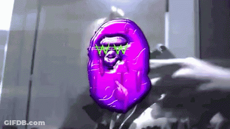 A Person Is Holding A Purple Object With A Monkey Face On It In Their Hand . GIF