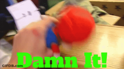 A Person Is Holding A Red Ball With The Words Damn It Written In Green GIF