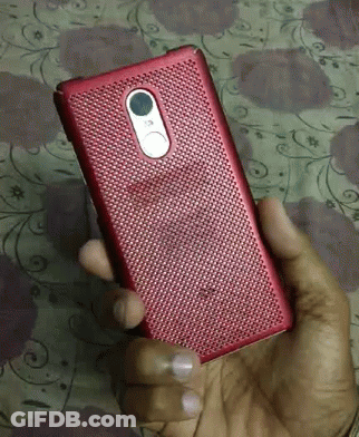 A Person Is Holding A Red Cell Phone In Their Right Hand GIF