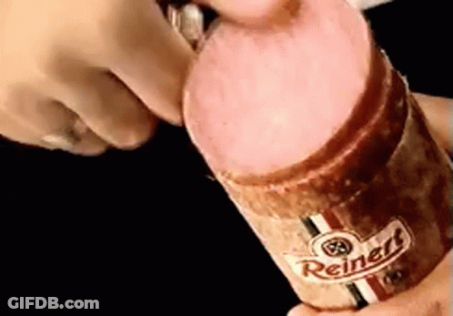 A Person Is Holding A Reinert Sausage In Their Hands GIF