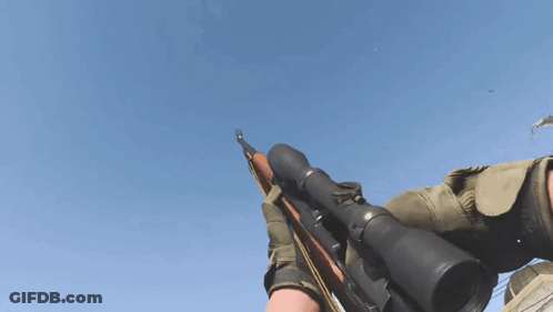 A Person Is Holding A Rifle With A Scope On It Against A Blue Sky GIF