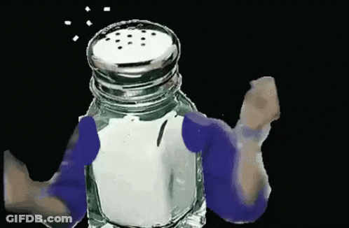 A Person Is Holding A Salt Shaker With Salt Coming Out Of The Top . GIF