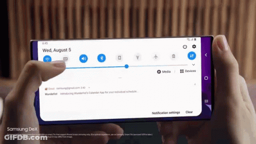 A Person Is Holding A Samsung Dex Phone In Their Hand GIF