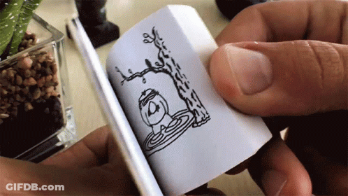 A Person Is Holding A Small Book With A Drawing Of A Tree And A Bird On It GIF
