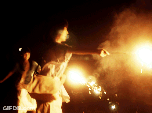 A Person Is Holding A Sparkler In Their Hand In The Dark GIF