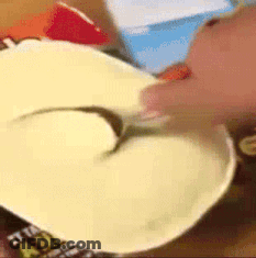 A Person Is Holding A Spoon In A Bowl Of Food .. GIF